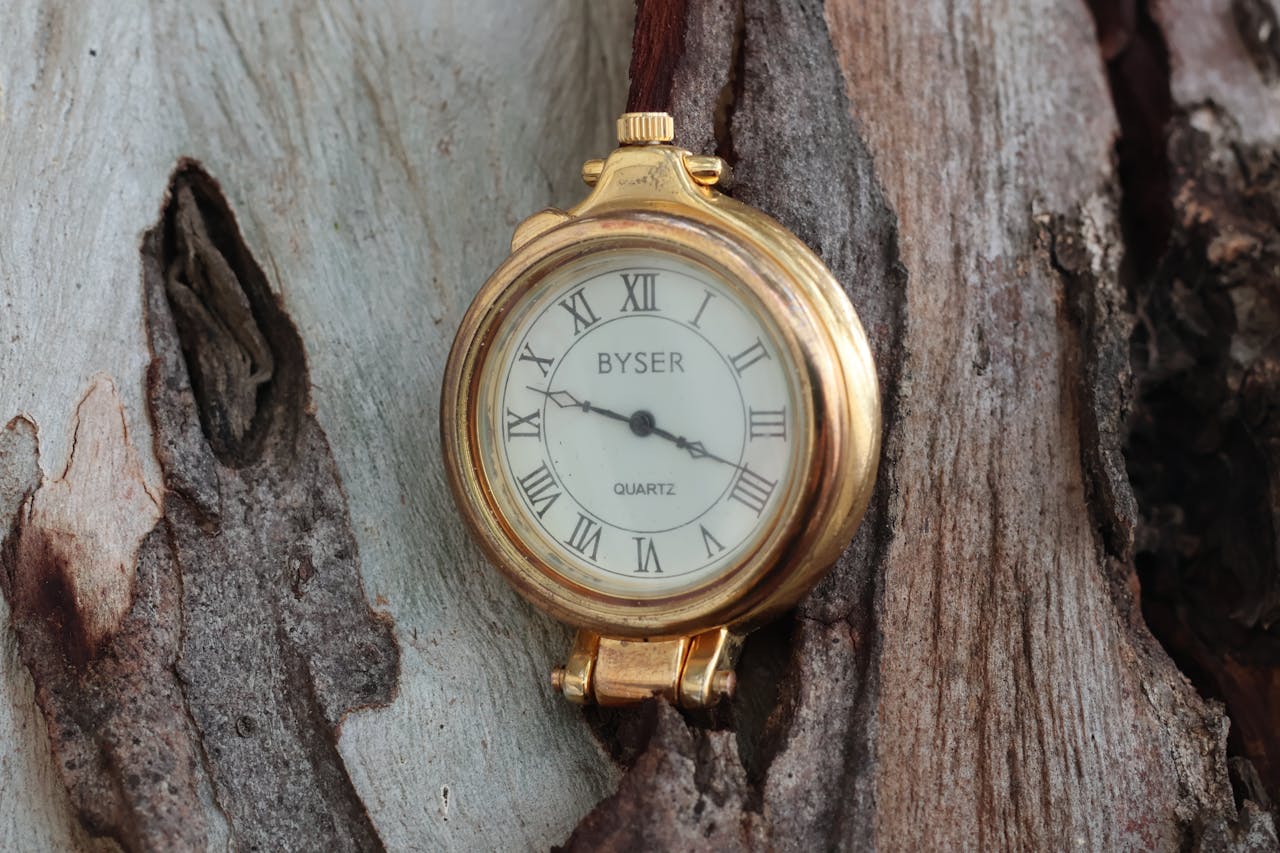 Gold vintage Byser watch with Roman numerals captured against a textured wooden background.