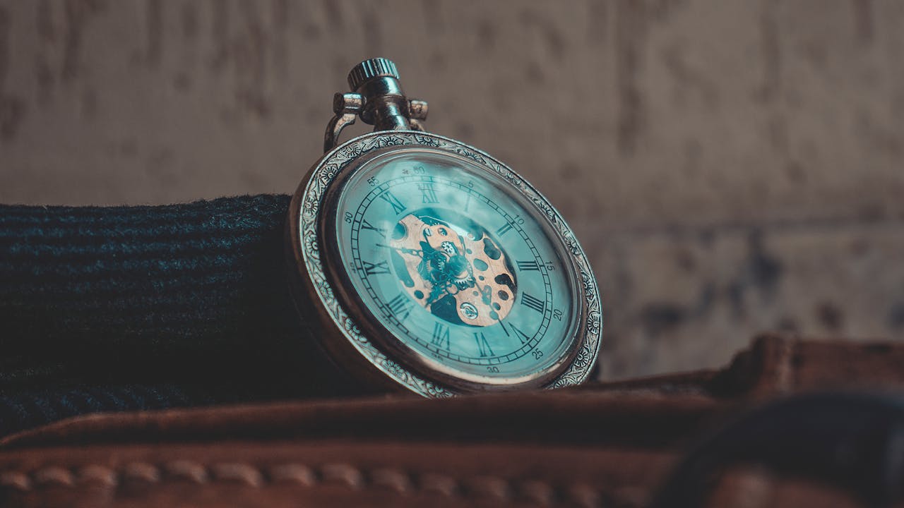 A detailed close-up of a classic vintage pocket watch with Roman numerals, showcasing intricate craftsmanship.